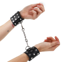 Белезници KINK - WRIST RESTRAINTS WITH SNAP FASTEN FULL OF RIVETS BLACK ADJUSTABLE 19-24 CM X 5.5 CM